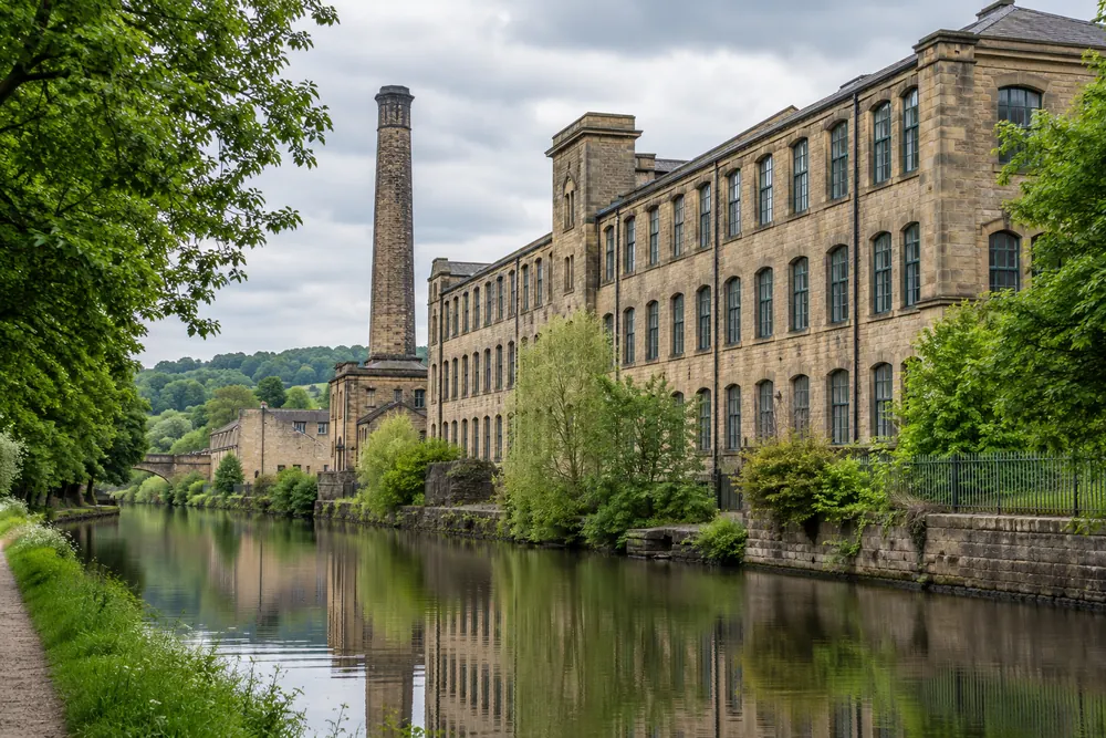 Sandstone textile mill buildings beside a West Yorkshire canal